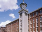 brick building with a white tower with a clock on it in the middle of the brick building